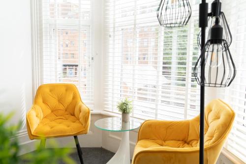 a living room with two chairs and a glass table at Open Mind Property - HotTub, 8 Beds & 2 Car Spaces in Portsmouth