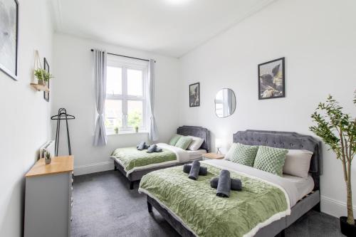 a white room with two beds and a window at Open Mind Property - HotTub, 8 Beds & 2 Car Spaces in Portsmouth