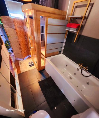 La petite salle de bains est pourvue d'une baignoire et de toilettes. dans l'établissement StarWars SAUNA Jacuzzi balneo à 10 minutes de Disneyland, à Condé-Sainte-Libiaire