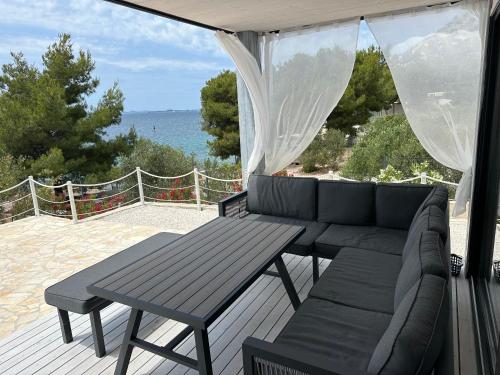 eine Terrasse mit einem Sofa und einem Tisch auf einer Terrasse in der Unterkunft BEACHHOUSE #1 - Buqez Resort in Drage