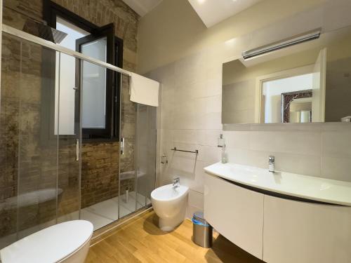 een badkamer met een wastafel, een toilet en een douche bij Appartamento Adiosa in Cagliari