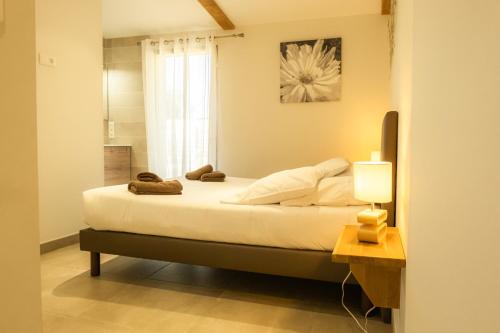 a bedroom with a bed with a lamp and a window at Domaine Saint Thomas in Argelès-sur-Mer