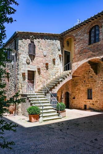 a brick building with stairs in front of it at Palazzo Massaini - Le Scuderie in Pienza