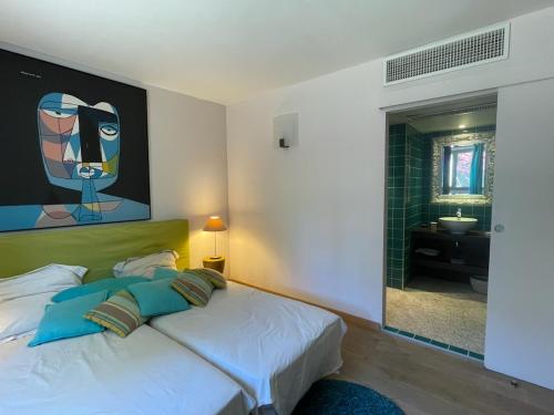 une chambre avec un lit avec un tableau sur le mur dans l'établissement Très belle villa Vue magnifique sur Saint Tropez Grimaud, à Grimaud