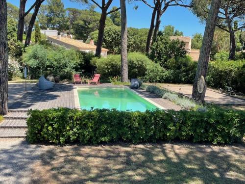 une piscine dans un jardin avec des buissons et des arbres dans l'établissement Très belle villa Vue magnifique sur Saint Tropez Grimaud, à Grimaud