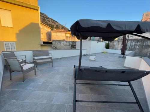 a patio with chairs and an umbrella on a roof at Sa Troppa de sos chentu in Dorgali