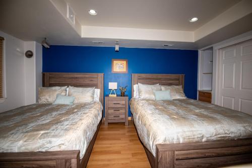 2 letti in una camera da letto con pareti blu di InHomeStays a Lakewood