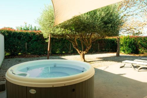 a hot tub in a yard with an umbrella at Domaine Saint Thomas in Argelès-sur-Mer