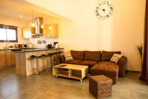 a living room with a couch and a clock on the wall at Domaine Saint Thomas in Argelès-sur-Mer