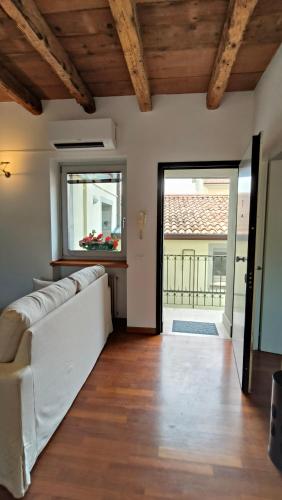 a living room with a white couch and a window at Sottocastello 3 in Gorizia