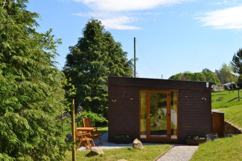 a small cabin with a picnic table in a garden at The Hive Lodge Cabin at Ashes Farm, near Settle in Settle