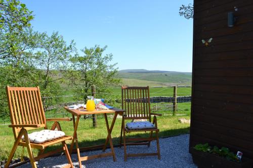 a table and two chairs sitting next to a table at The Hive Lodge Cabin at Ashes Farm, near Settle in Settle