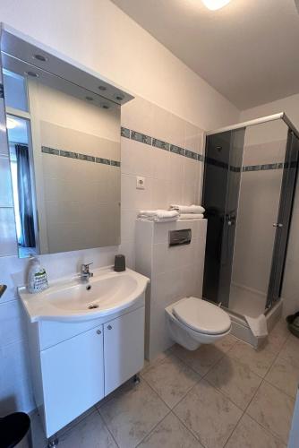 a bathroom with a sink and a toilet and a shower at Tip- top in Karlobag