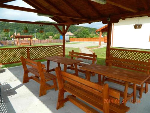 a group of wooden benches sitting under a pavilion at Casa Loksi in Sovata