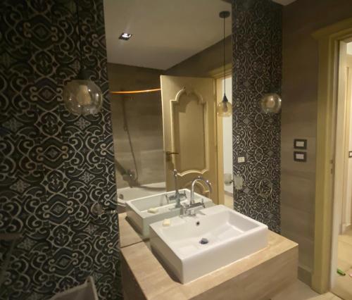 La salle de bains est pourvue d'un lavabo blanc et d'une baignoire. dans l'établissement 2 Bedrooms Apartment, Close to Airport, au Caire