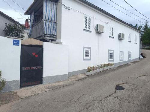 a white building on the side of a street at Apartment in family house Linda in Čavle