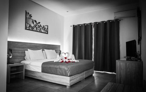a bedroom with a bed with a flower arrangement on it at Vallian Village Hotel in Paradeísion