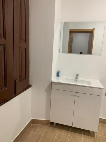 a bathroom with a white sink and a mirror at Casa de Pedra in Pedrógão Grande