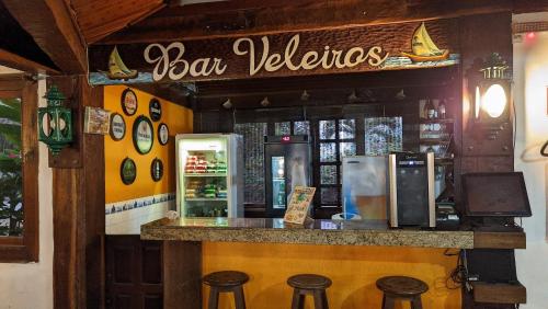 a bar with stools in front of a restaurant at Pousada dos Veleiros in Nova Almeida