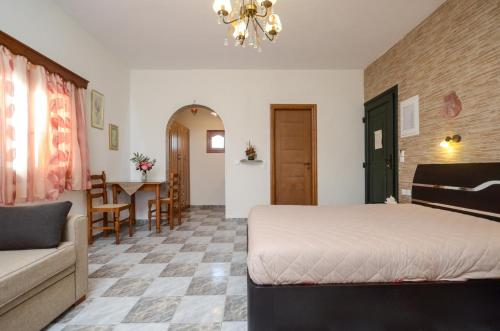 a bedroom with a bed and a couch and a table at Orama Apartments in Agia Anna Naxos