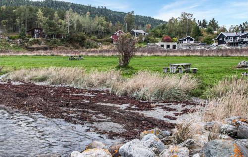 a picnic table in a field next to a river at Stunning Home In Frosta in Tautra