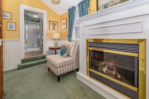 a living room with a fireplace and a chair at Holiday Guest House Bed & Breakfast in Wells