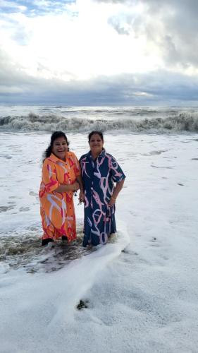two people standing in the water at the beach at Marari Beach Villas in Mararikulam