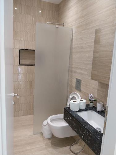 a bathroom with a toilet and a sink and a tub at LUXURY Stay By the Beach in Neoi Epivates