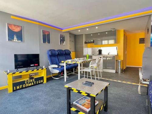 un salon avec une table et une cuisine dans l'établissement Objectif Cosmos Magnifique T2 à 4 min du parc, à Chasseneuil-du-Poitou