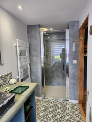 a shower with a glass door in a bathroom at Gîte du clos marty in Sébrazac