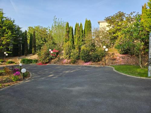 a driveway with trees and flowers and a house at A l'escale fleurie in Guipavas