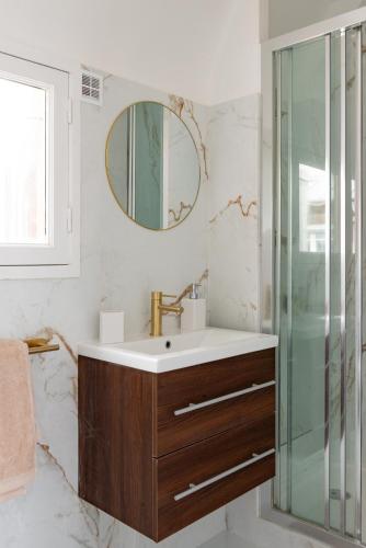 une salle de bain avec un lavabo et un miroir dans l'établissement Appartement 75017 proche Champs Elysées, à Paris