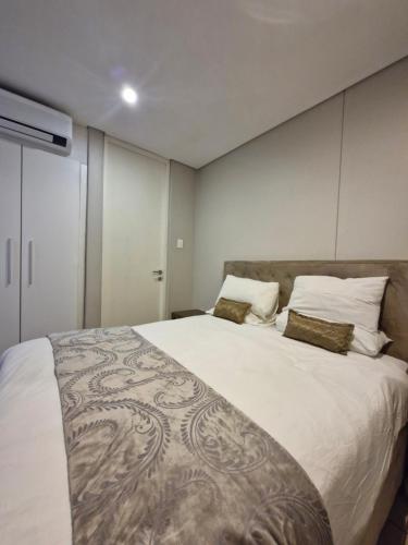 a bedroom with a large white bed with two pillows at Accommodation Front - Ocean View 2 Sleeper in Durban