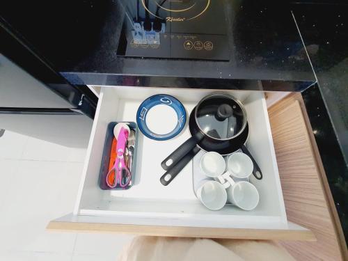 a drawer with various items inside of a microwave at 马六甲 Melaka Amber cove residence Jonker Street in Melaka