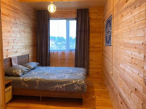 a bedroom with a bed in a wooden cabin at Beach HOUSE in Cholpon-Ata