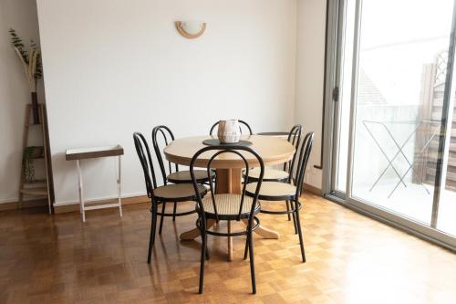 une table et des chaises dans une pièce avec une fenêtre dans l'établissement Appartement Rénové 10 minutes à Pied du Coeur de Colmar, à Colmar