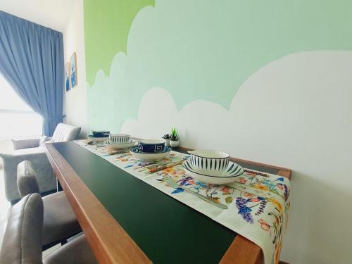 a dining room table with bowls and plates on it at 马六甲 Melaka Amber cove residence Jonker Street in Melaka