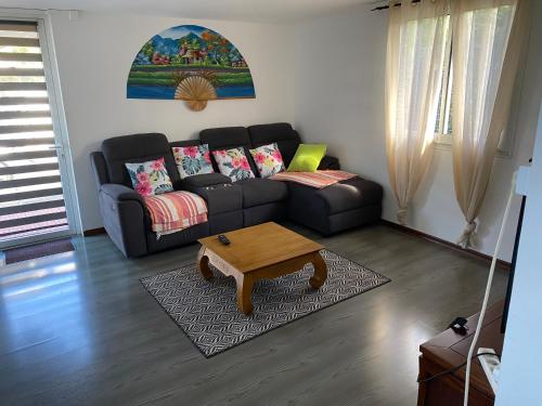 a living room with a couch and a coffee table at Au Champ de Cannes in Petite Île
