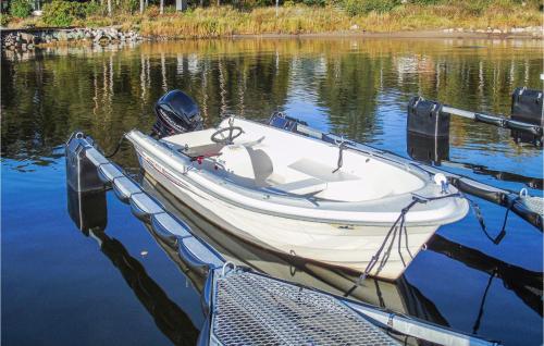 a white boat tied to a dock in the water at 3 Bedroom Awesome Apartment In Skjeberg in Skjeberg