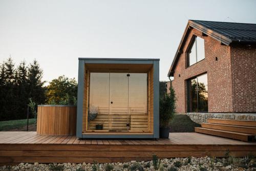 a house with a glass door on a wooden deck at Bohdašín 17 in Červený Kostelec