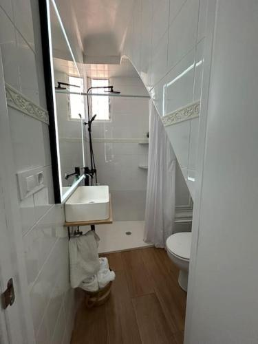 a bathroom with a sink and a toilet and a mirror at Casa Calle Pilar in Fuentes de Andalucía