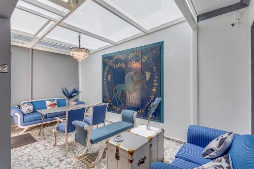 a living room with blue chairs and a painting at The Condesa House in Mexico City