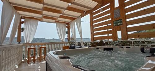 a bath tub in a room with a balcony at Holiday Home Peran in Grebaštica