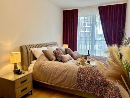 a bedroom with a large bed with pillows on it at Apartamenty Bryza nad jeziorem in Augustów