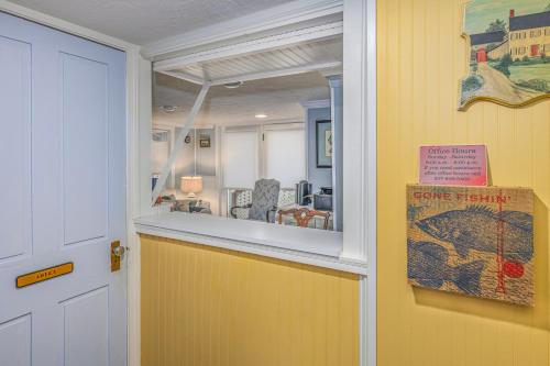 a yellow room with a window and a sign on a door at Holiday Guest House Bed & Breakfast in Wells