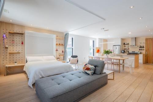 a bedroom with a bed and a couch and a kitchen at Chez moi - Plateau - Superbe Stay - Excellent emplacement - très confortable - in Montréal
