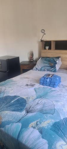 - un lit avec une couverture bleue dans l'établissement Kecyhouse chambre PROMESSE de l'Aube, à Sevran