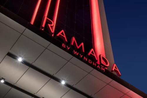 a neon sign on the side of a building at Ramada by Wyndham Riyadh King Fahd Road in Riyadh