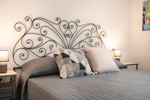 a bedroom with a bed with a metal headboard at Villa Silvia Apartments in La Maddalena