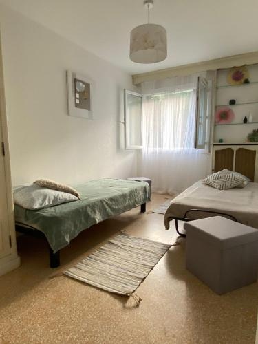 Cette chambre comprend 2 lits, une fenêtre et un tapis. dans l'établissement Grand Appartments Sappia, à Nice